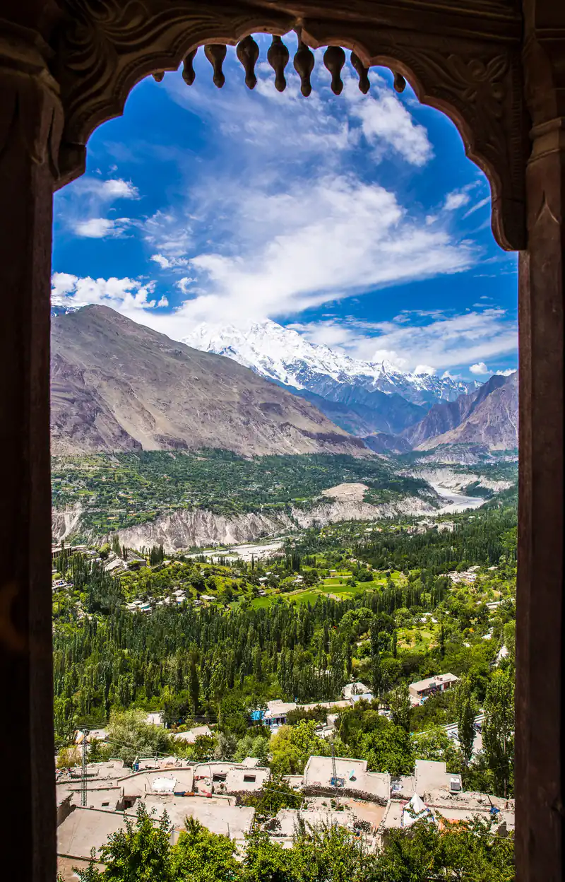 Hunza Valley and snowy peaks seen through a window of Altit Fort
